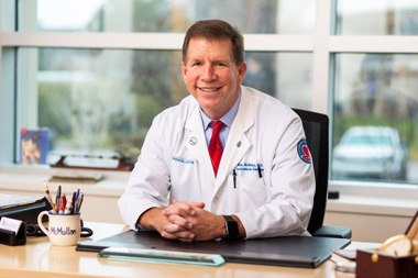 Dr. McMullan sitting at his desk